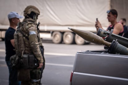 Dos residentes de Rostov se fotografían con un miembro de Wagner. En primer plano, dos lanzagranadas en un vehículo.