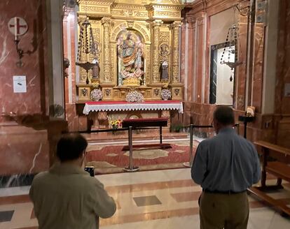 Dos personas observan en lugar donde estaba enterrado Queipo de Llano hasta esta mañana. La tumba ha sido tapada con una alfombra.