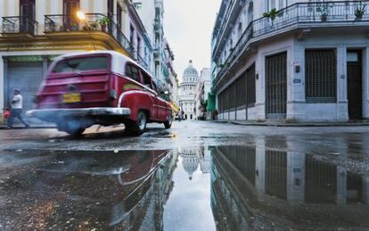 Un coche antiguo por las calles de La Habana, con el Capitolio al fondo. 