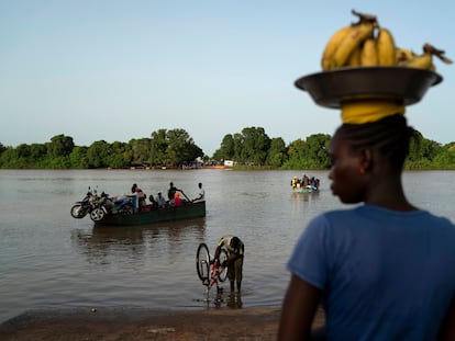 Una mujer espera un bote para cruzar el río Gambia en Bansang, Gambia, para vender bananas.