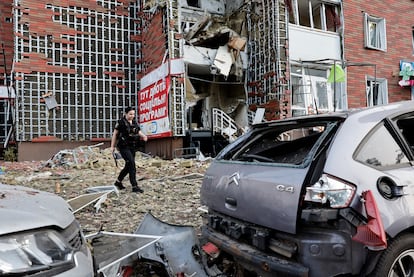 Un policía camina cerca de un edificio de apartamentos dañado tras el impacto de un dron ruso en Kiev. 