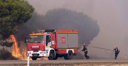 Trabajos de extinción este domingo en la carretera que une Mazagón y Matalascañas.