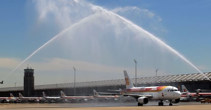 El avión de la selección pasa por debajo de un arco de agua hecho por bomberos.