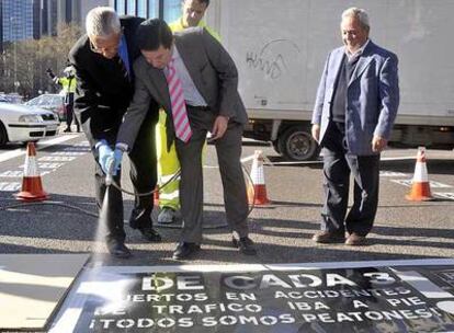 Pedro Sauret y Pedro Calvo pintan el lema de la campaña en un paso de peatones.