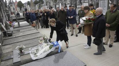 La viuda de Fernando Múgica coloca un ramo de flores en presencia de sus hijos.