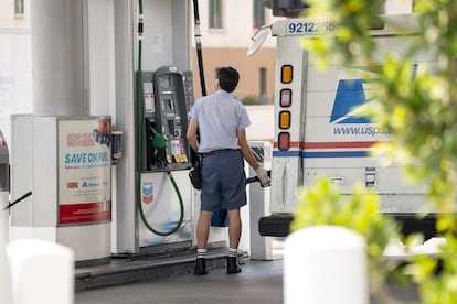 Un conductor del Servicio Postal de Estados Unidos carga gasolina en el centro de Los Ángeles, California.