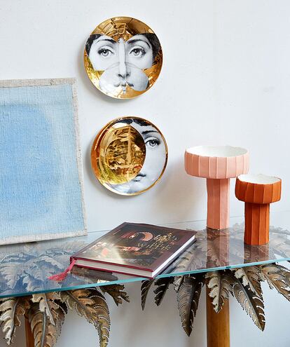 Platos de FORNASETTI (160 €/u); cuadro de ANKE BLAUE (2.500 € a 8.000 €); libro de BILL WILLIS (Majorelle, 83 €), «el decorador de YSL en Marrakech»; jarrones de PAOLA PARONETTO (98 € y 104 €), «con unos colores maravillosos»; y consola de palmeras de MAISON JANSEN (8.500 €), «una pieza vintage».