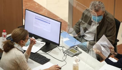 Una funcionaria atiende a dos personas en una oficina de la Agencia Tributaria en Madrid.