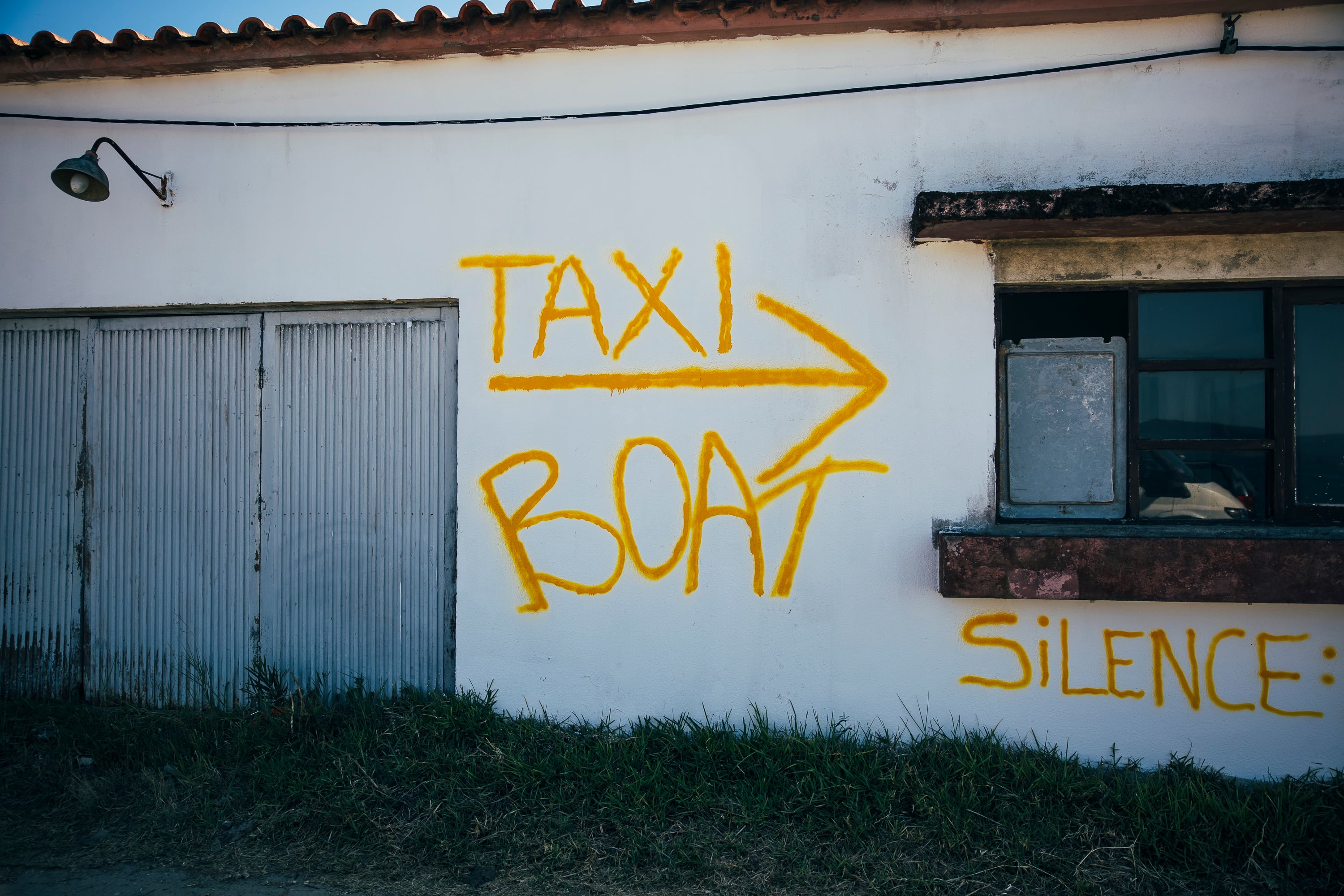 Pintada que anuncia un servicio de bote para cruzar el Miño desde Caminha.