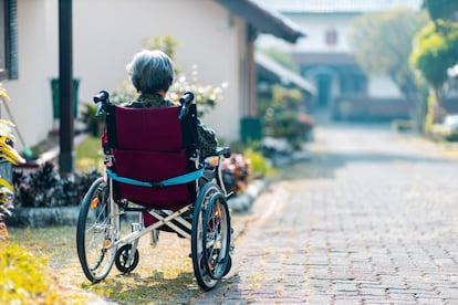 Una mujer, sentada en su silla de ruedas.