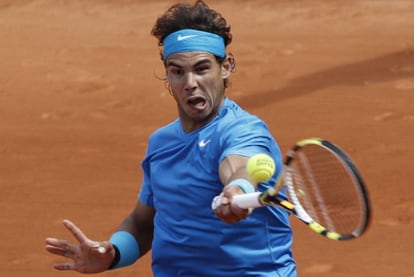 Nadal plays a return during his tough opening match against John Isner.