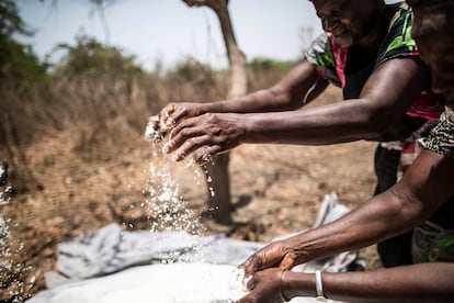 Unas mujeres comprueban el estado de la sal que extraen de la tierra, cerca de Quinhamel, región de Biombo, Guinea-Bisáu.