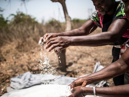 Unas mujeres comprueban el estado de la sal que extraen de la tierra, cerca de Quinhamel, región de Biombo, Guinea-Bisáu.