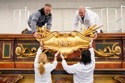 Marta Fernández de los Ríos, izquierda, Beatriz Burreros, el ebanista Miguel Ángel Ortega, derecha y Juan Andrés Martínez se disponen a colocar una de las piezas del altar.