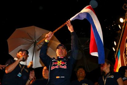 El piloto español Carlos Sainz ondea la bandera de Paraguay durante la ceremonia de presentación.