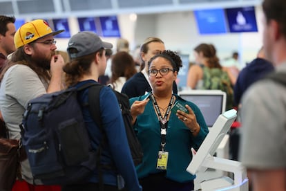 Los representantes de servicio al cliente de Delta ayudan a los viajeros ​​mientras esperan en las filas en Minneapolis.