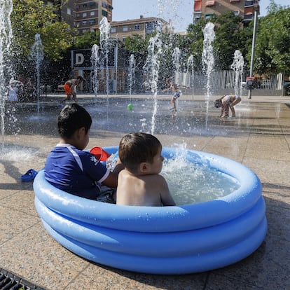GRANADA, SPAIN - JULY 17: Children try to cool off in a public fountain as temperatures soar above 40 degrees Celsius in Granada, Spain on July 17, 2025. The southern Spanish city continues to experience extreme heat conditions as part of the summer heatwave affecting the region. (Photo by Alex Camara/Anadolu via Getty Images)