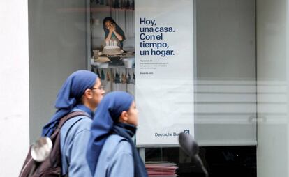 Dos religiosas pasan ante un cartel publicitario de una entidad bancaria en Valencia.