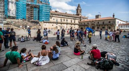 Turistas descansan en la plaza del Obradoiro en Santiago de Compostela.