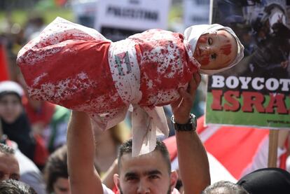 Un manifestante sostiene a un muñeco envuelto en una sábana ensangrentada en referencia a los niños palestinos muertos durante incursiones israelíes en Gaza, en un acto en apoyo al pueblo palestino en Ámsterdam. 20 de julio de 2014.