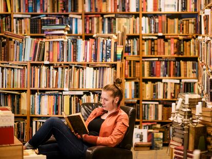 Una mujer lee en una biblioteca.