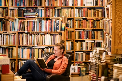 Una mujer lee en una biblioteca.