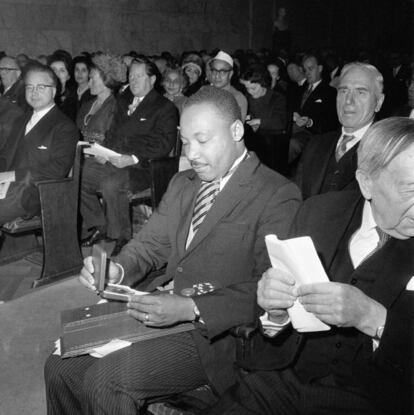 Martin Luther King, defensor de los derechos civiles en Estados Unidos, mira a su medalla que le certifica como el ganador Premio Nobel de la Paz en 1964.