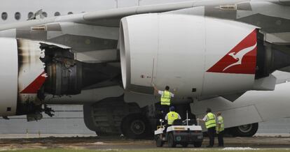 Los técnicos trabajan junto al motor dañado en el vuelo.