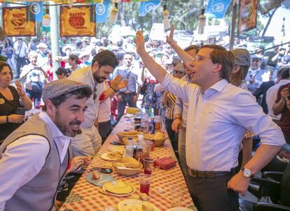 El candidato del PP a la alcaldía de Madrid, José Luis Martínez-Almeida (primero por la mano derecha), en la carpa del partido.