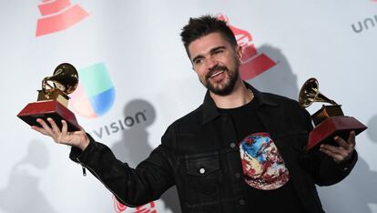 El artista colombiano Juanes posa con sus dos premios Grammy.