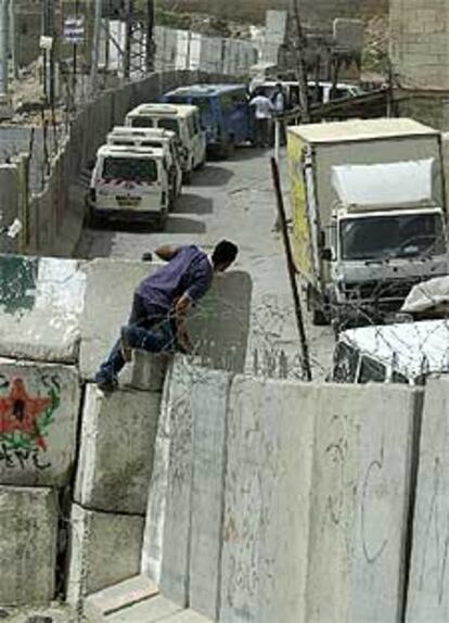 Un palestino salta el muro que separa Jerusalén de Cisjordania.