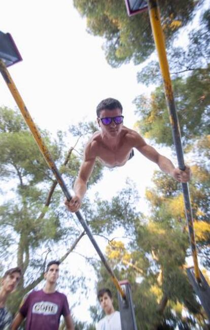 Un jovemn se ejercita en el parque de El Retiro.