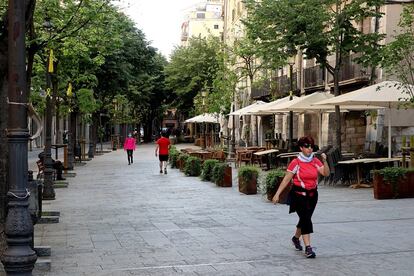 Varias personas se ejercitan por una calle de Girona. 