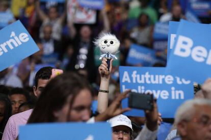 Una partidaria del candidato Bernie Sanders alza, entre las pancartas, un muñeco que representa al senador, en la Convención Nacional Demócrata de Filadelfia.