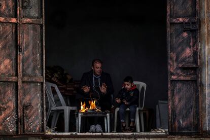 Un refugiado palestino y su hijo entran en calor junto a una pequeña fogata improvisada en su casa en el campo de refugiados de Al Shateaa, durante la ola de frío que afecta la Franja de Gaza. Los habitantes de Gaza, hogar de 1,8 millones de personas, sufren alrededor de 16 cortes de electricidad al día, por lo que el uso de baterías, generadores o velas es habitual.