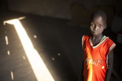 Malat de 9 años de pie en la iglesia en la que él y su familia se han refugiado desde que llegaron a Nimule en Sur Sudán