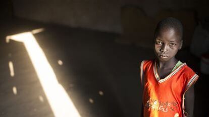 Malat de 9 años de pie en la iglesia en la que él y su familia se han refugiado desde que llegaron a Nimule en Sur Sudán