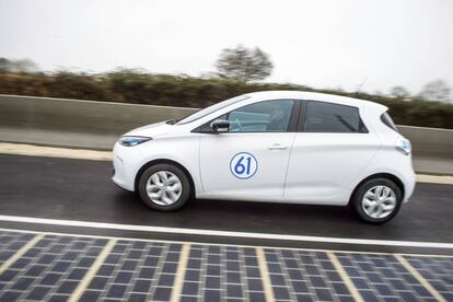 Un coche el&eacute;ctrico conduce en la primera carretera equipada con paneles solares, en Tourouvre au Perche, Francia. 