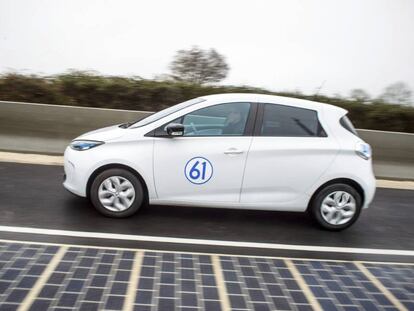 Un coche el&eacute;ctrico conduce en la primera carretera equipada con paneles solares, en Tourouvre au Perche, Francia. 