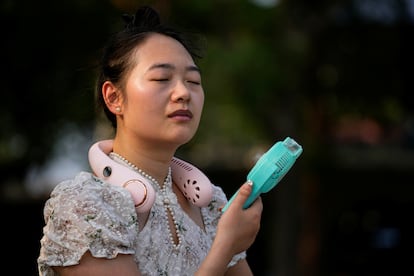 Una mujer usa un pulverizador de agua en una calle de Shanghái (China), el 12 de julio. 