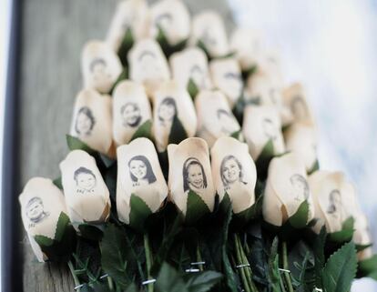 Un ramo de rosas blancas con las fotografías de las víctimas de la tragedia.
