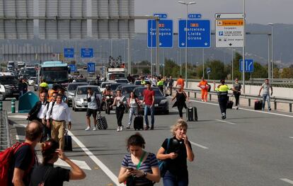 Viajeros obligados a caminar con sus maletas para alcanzar el aeropuerto de El Prat