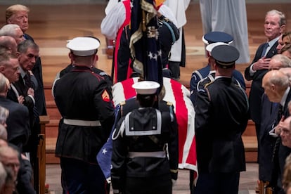 El presidente Donald Trump y el expresidente George Bush, hijo de George H. W. Bush, observan la llegada del ataúd al funeral de Estado.