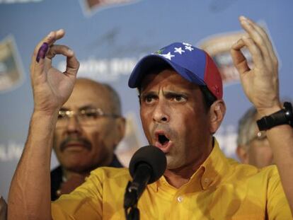 Opposition presidential candidate Henrique Capriles talks to journalists after official results of the elections were announced in Caracas.