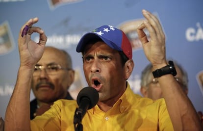 Opposition presidential candidate Henrique Capriles talks to journalists after official results of the elections were announced in Caracas.