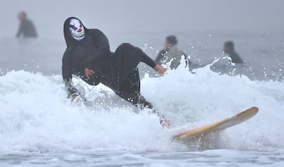 Un hombre ataviado con una máscara de payaso practica surf durante el Blackie's Halloween Surfing, en Newport Beach, California (Estados Unidos), el 27 de octubre de 2018.