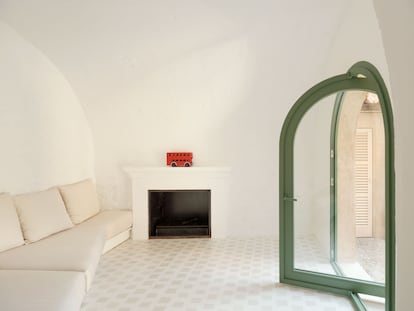 Una puerta acampanada y un sofá con forma de trapecio dan singularidad a la sala de estar, que cuenta con chimenea.