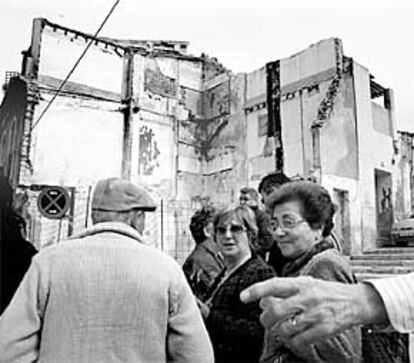 Un grupo de vecinos, ayer, ante uno de los solares abandonados en el barrio de San Antón.