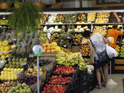 Una mujer elige fruta en un mercado. 