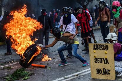 Un activista opositor quema una rueda durante las protestas contra el Gobierno, en Caracas.